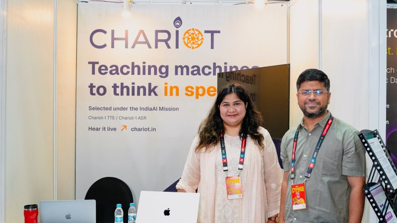 Two members of the Chariot team at the booth, with demo laptops on the counter