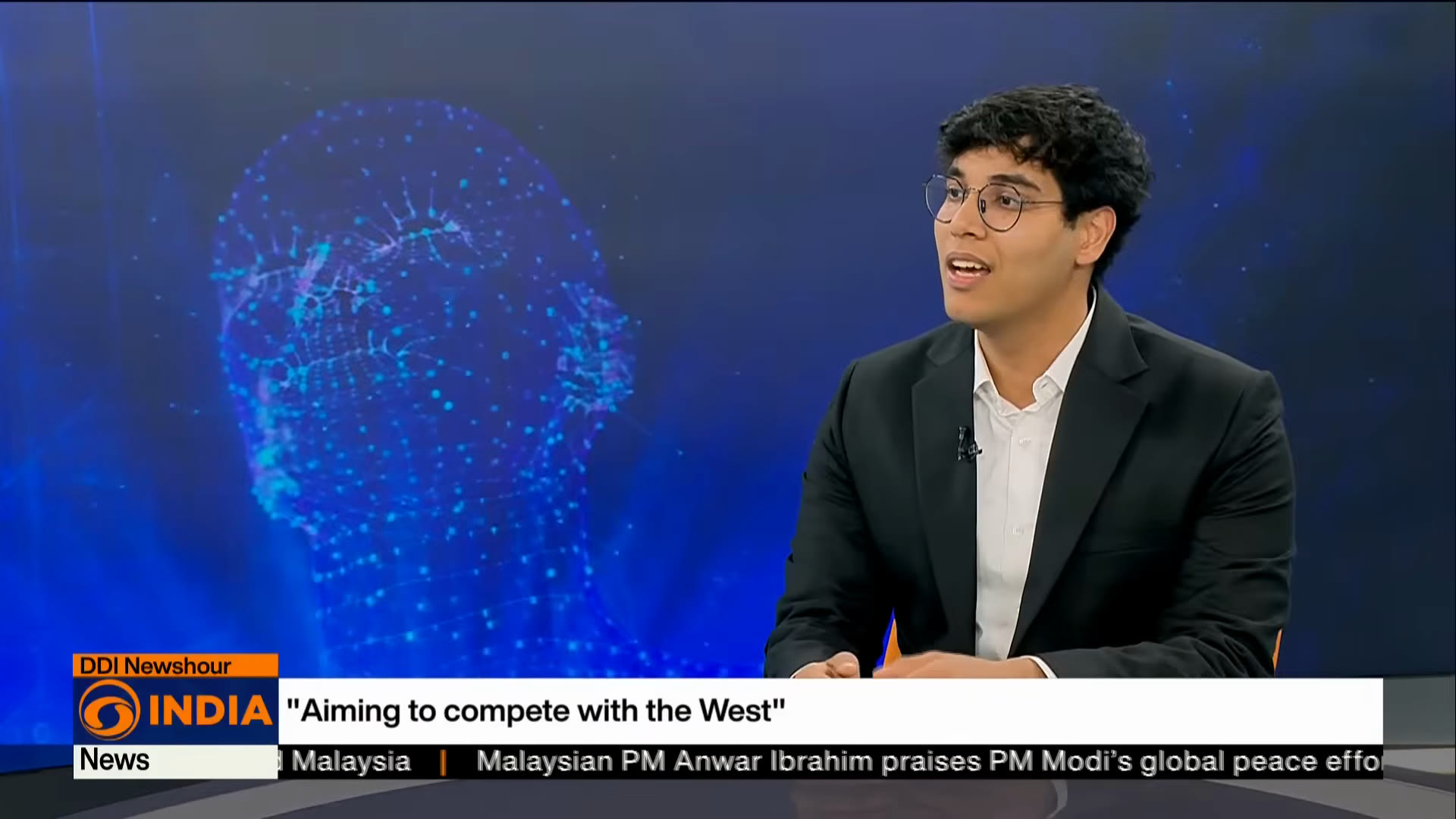 Parth Sarthi on the DD India Newshour set, under the caption “Aiming to compete with the West”