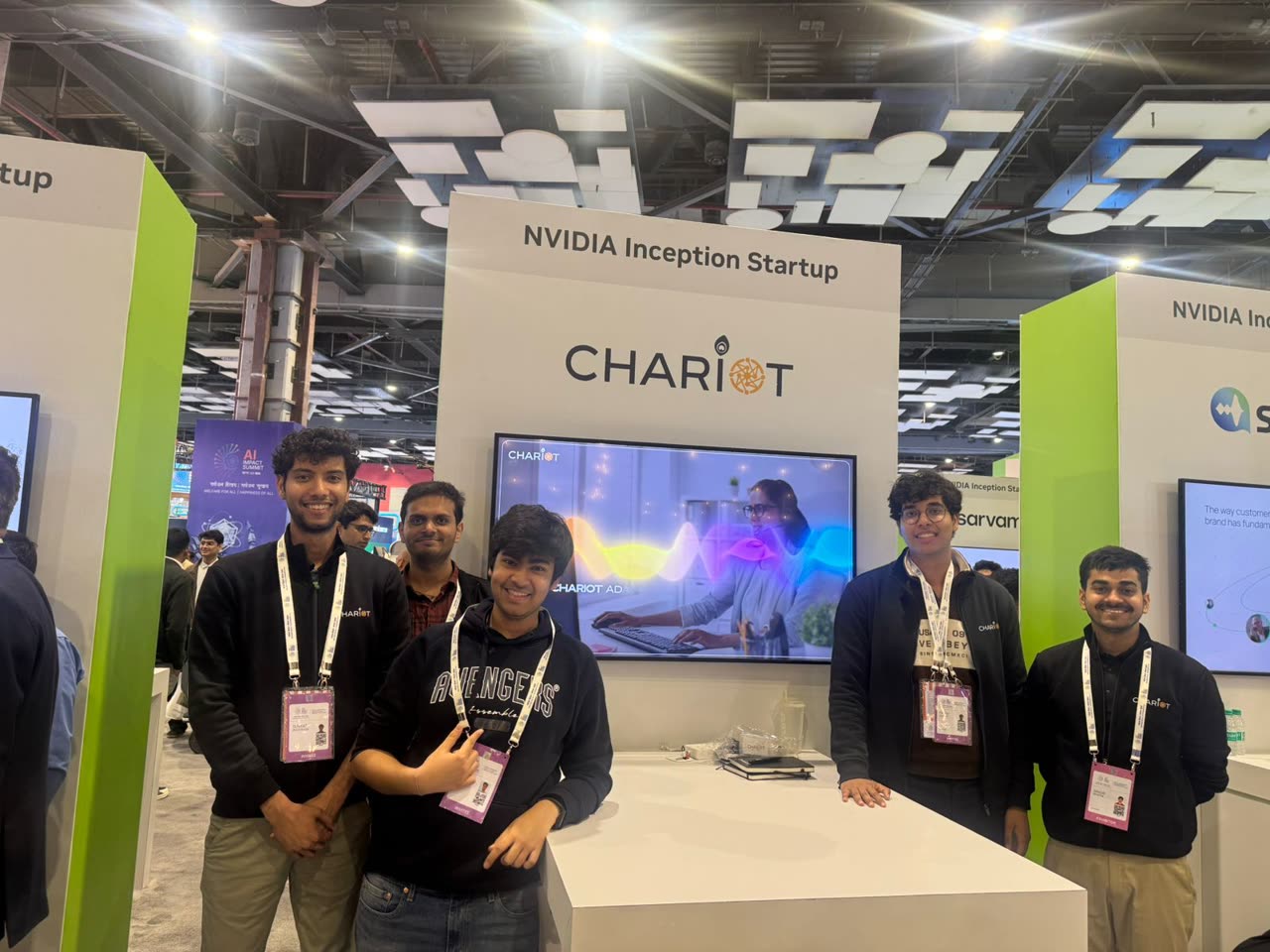 The team beside the booth's demo screen, showing the speech generation preview